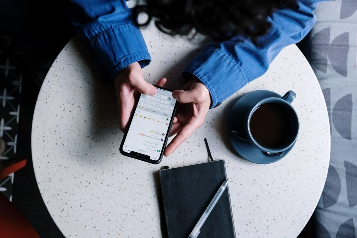 Hands typing a message on a phone.