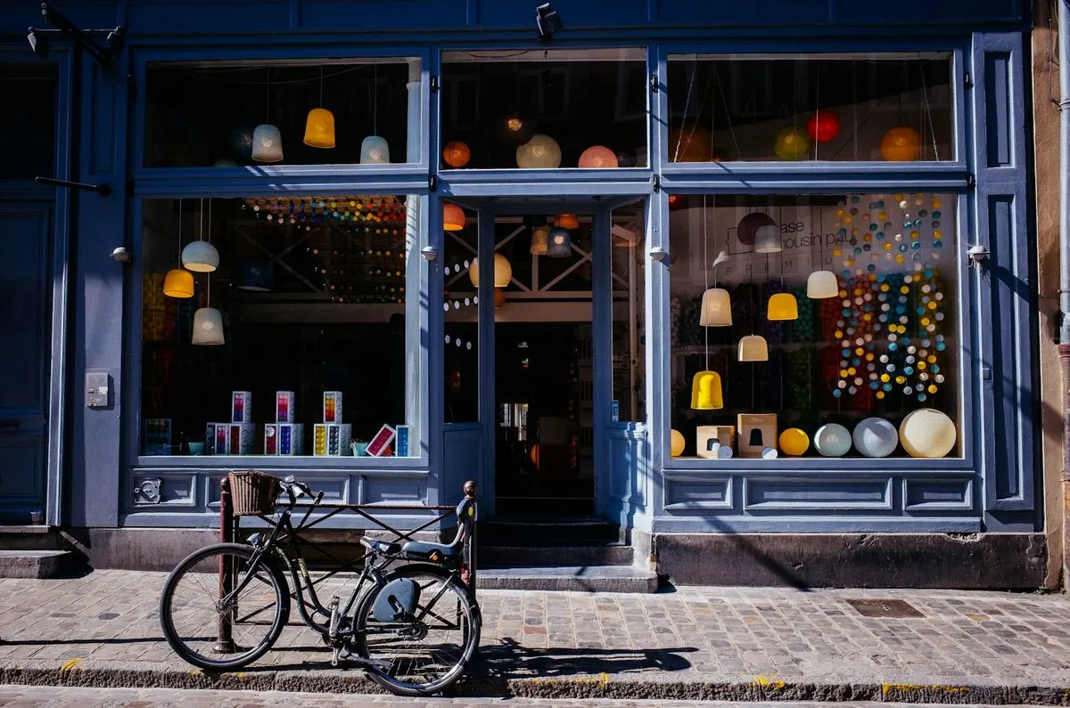 A blue shopfront with a bicycle on the pavement.