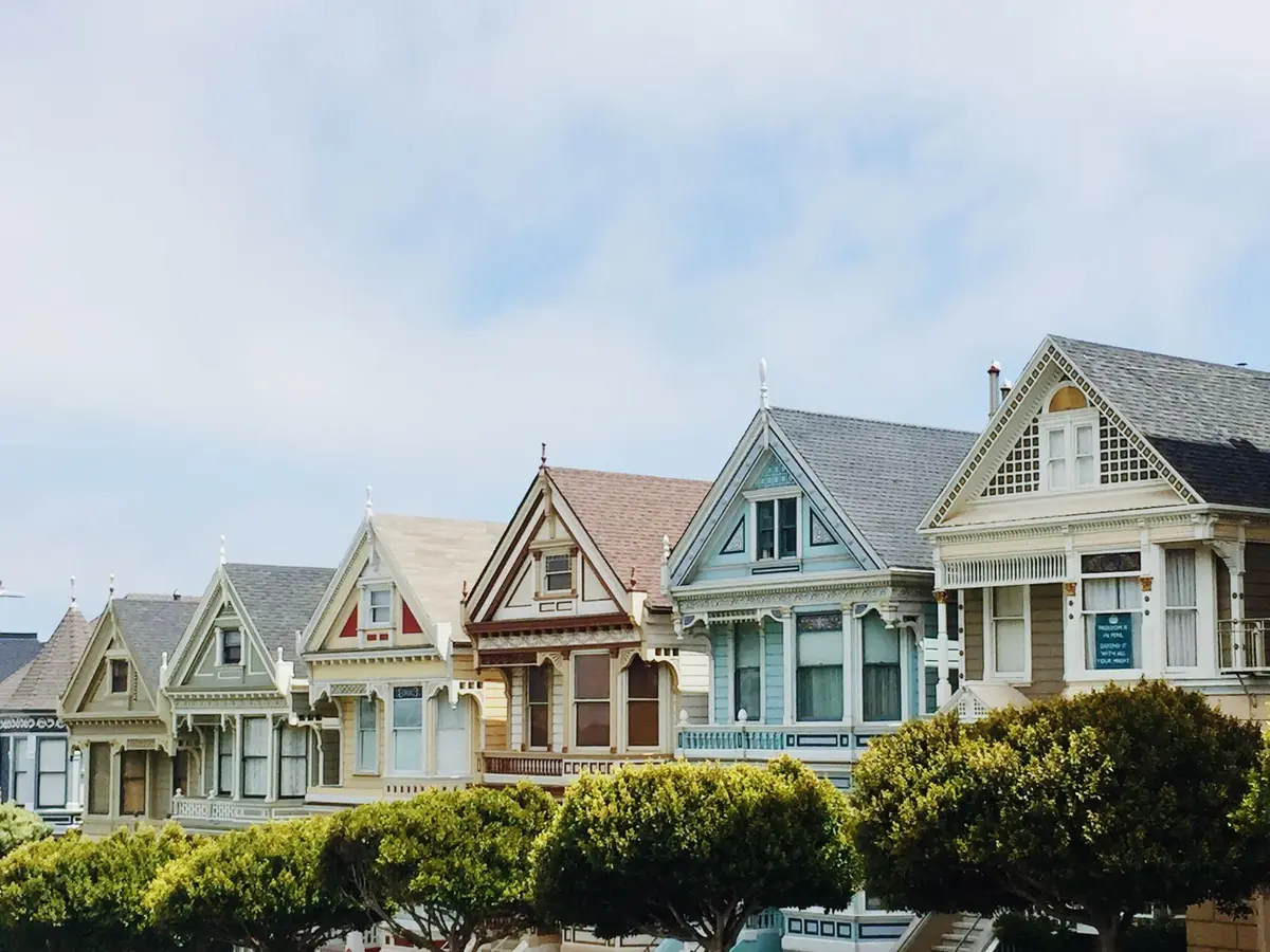 A row of painted houses on a quiet street.