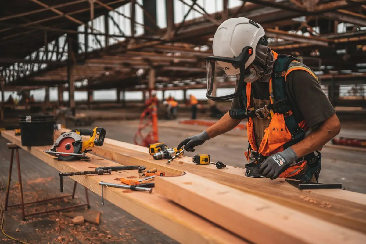 A tradesperson using a drill on timber.