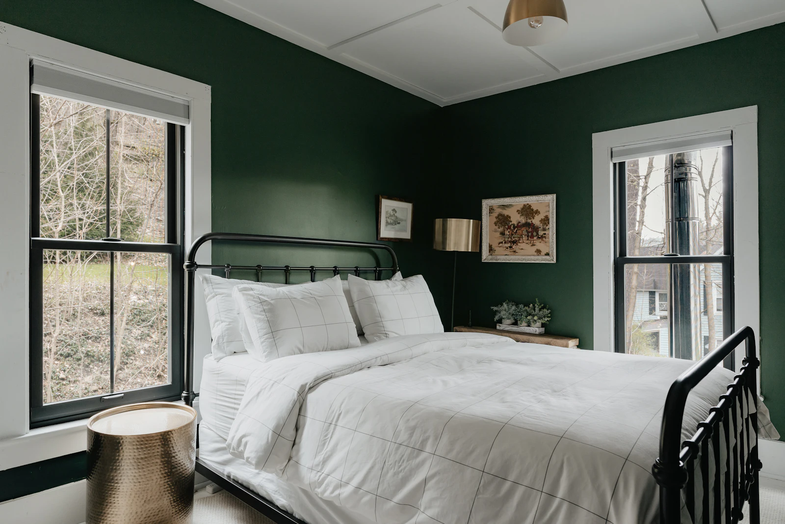Bedroom with deep green painted walls and white woodwork